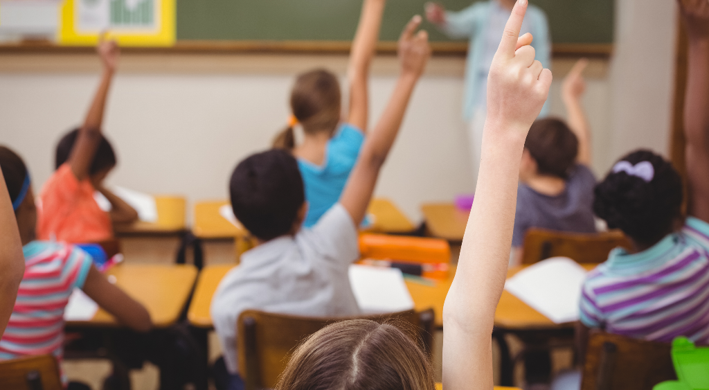 children raising hand in class